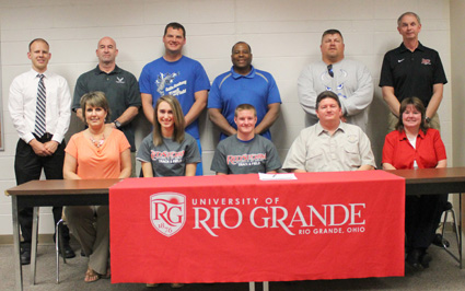Gallia Academy's Madelynn Dennison and Jeremy Wilson (seated center) pose with family and coaches after signing with Rio
